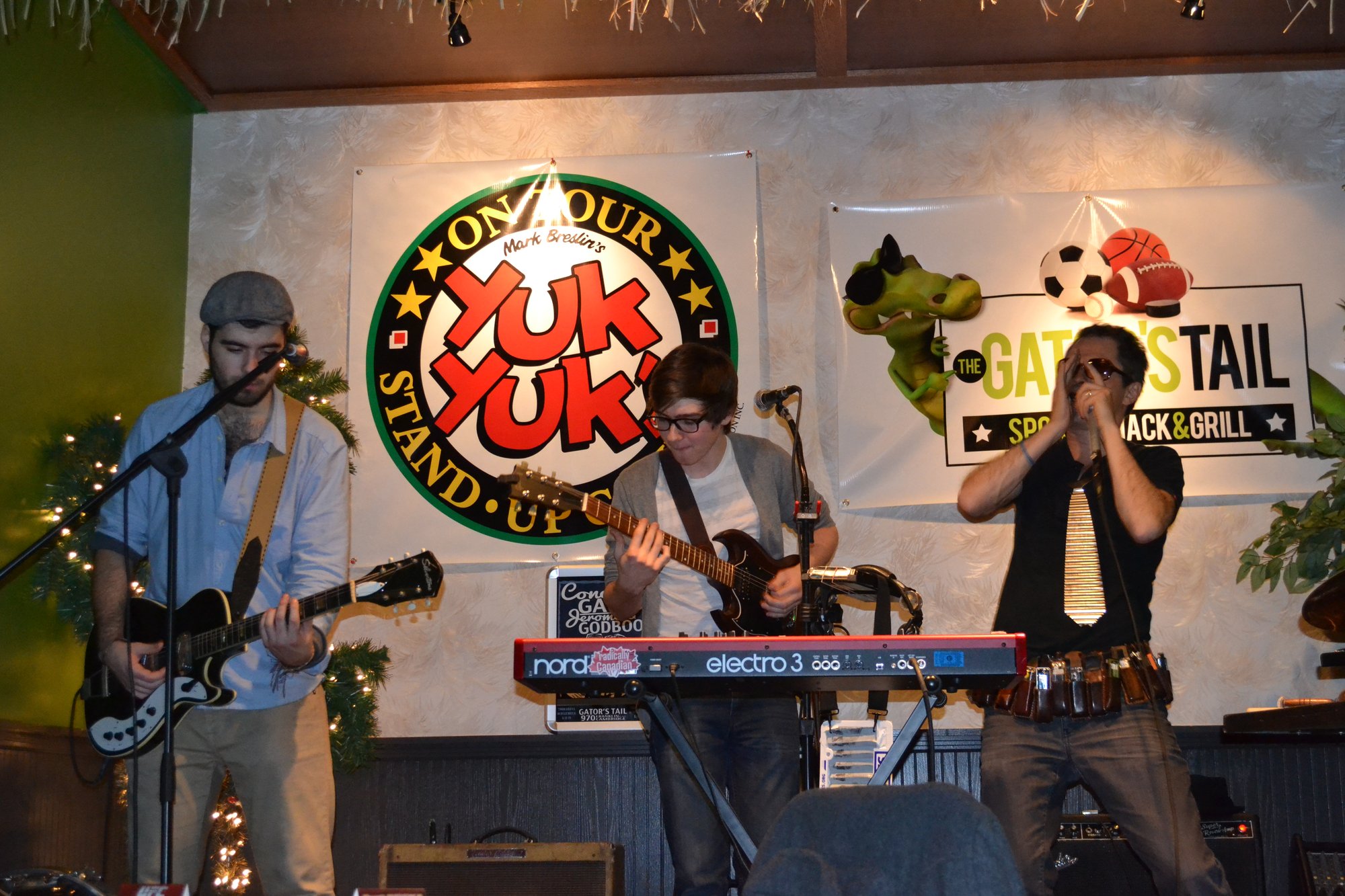 Live band playing under the Gator's Tail and Yuk Yuk's banners