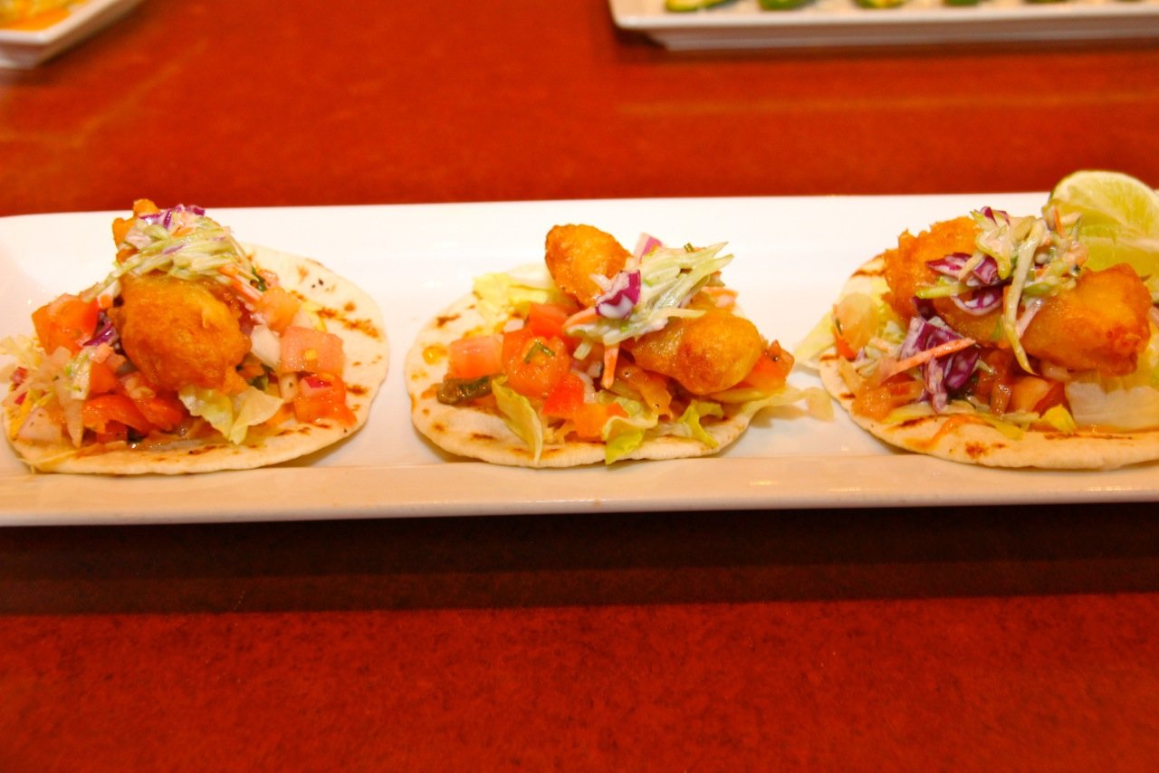 Fish tacos topped with pico de gallo and broccoli slaw