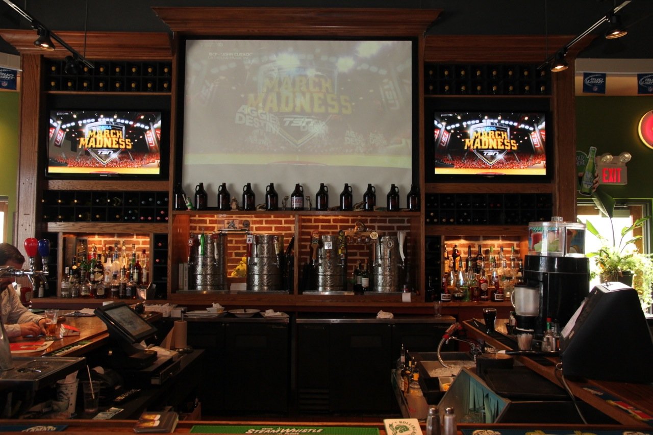 The bar at The Gator's Tail with taps, growlers and game-day screens